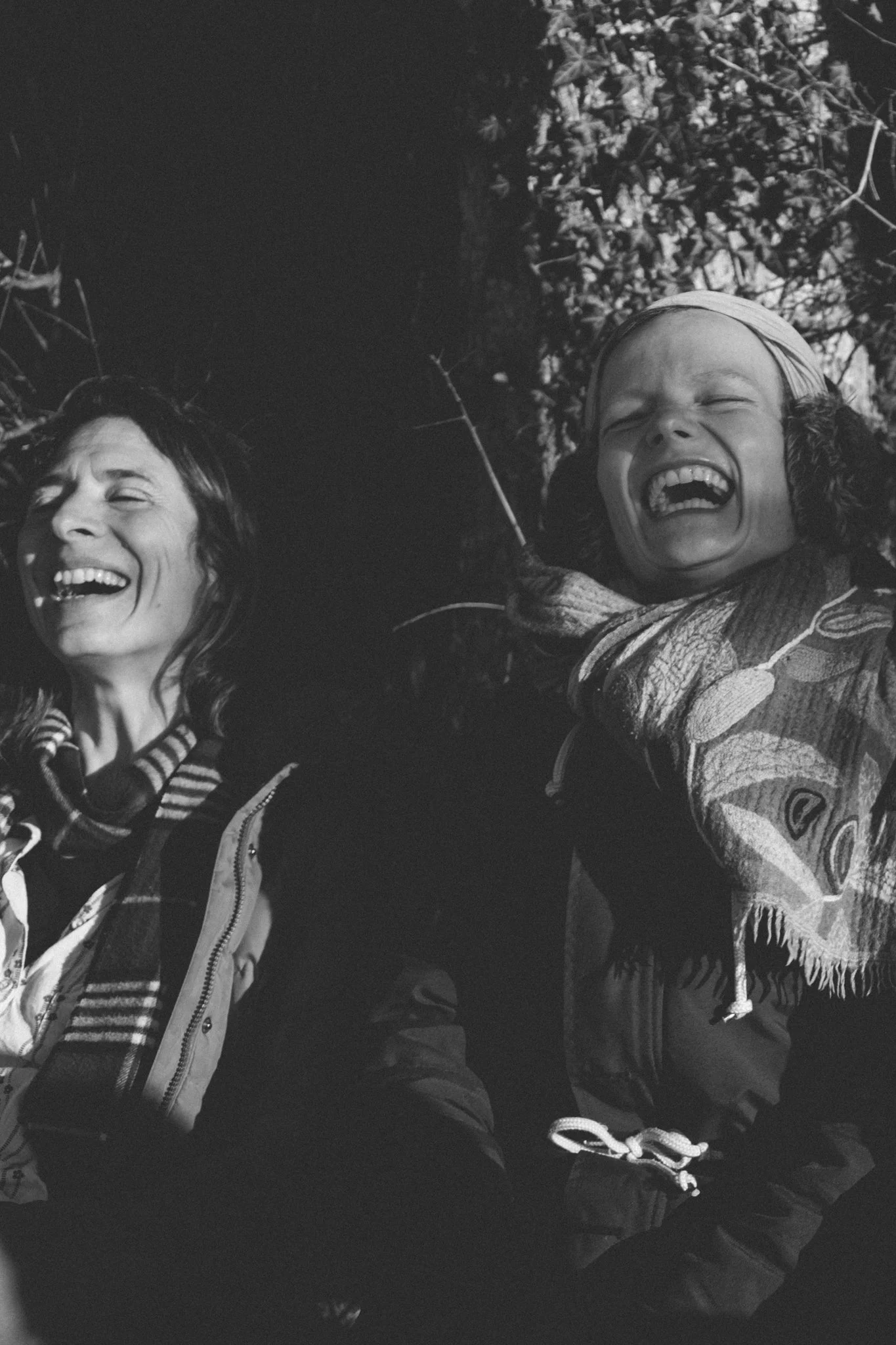 friends photoshoot - Two women lying on the ground outdoors, laughing and smiling.
