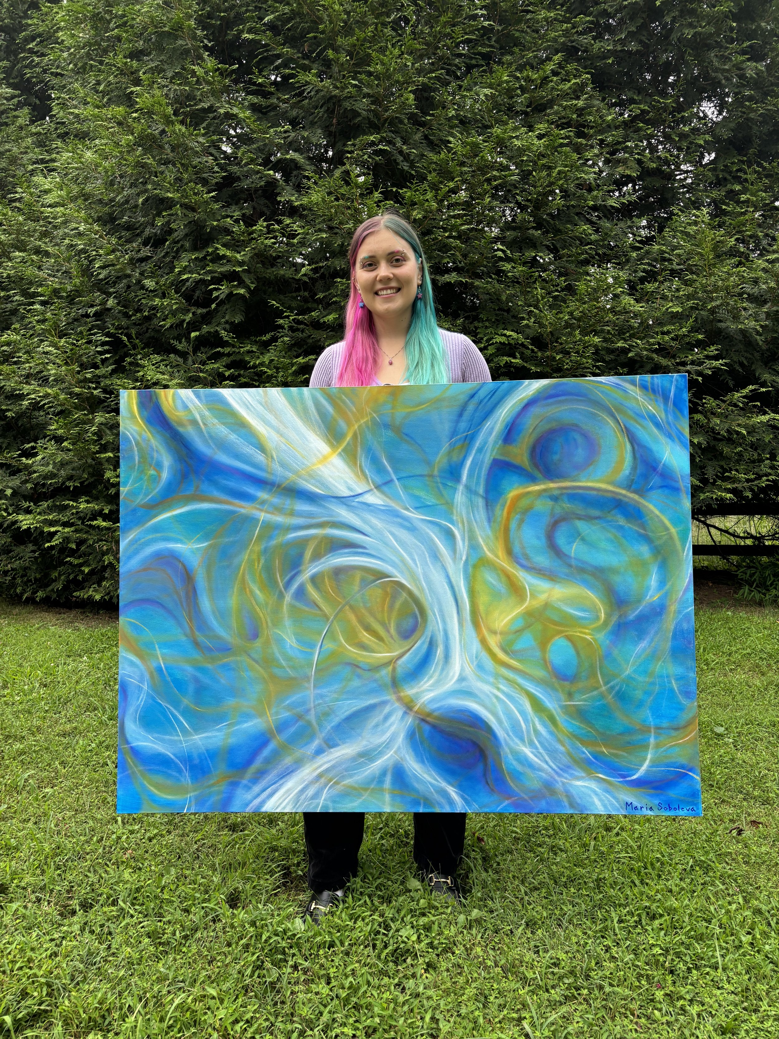 Artist Maria Soboleva holding a large blue and yellow abstract painting