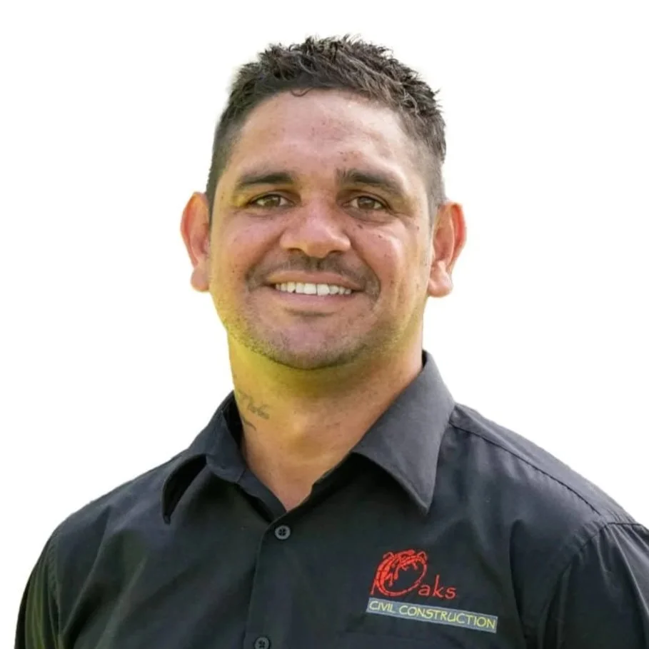 A man smiling, wearing a black polo shirt with a red and yellow logo and the words 'Oaks Civil Construction' on it.