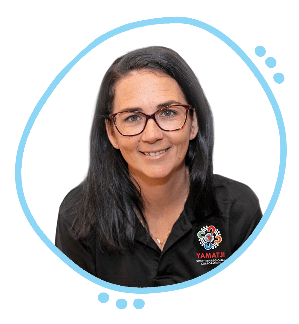 A smiling man with short light brown hair and blue eyes, wearing a dark gray shirt, posed against a white background.