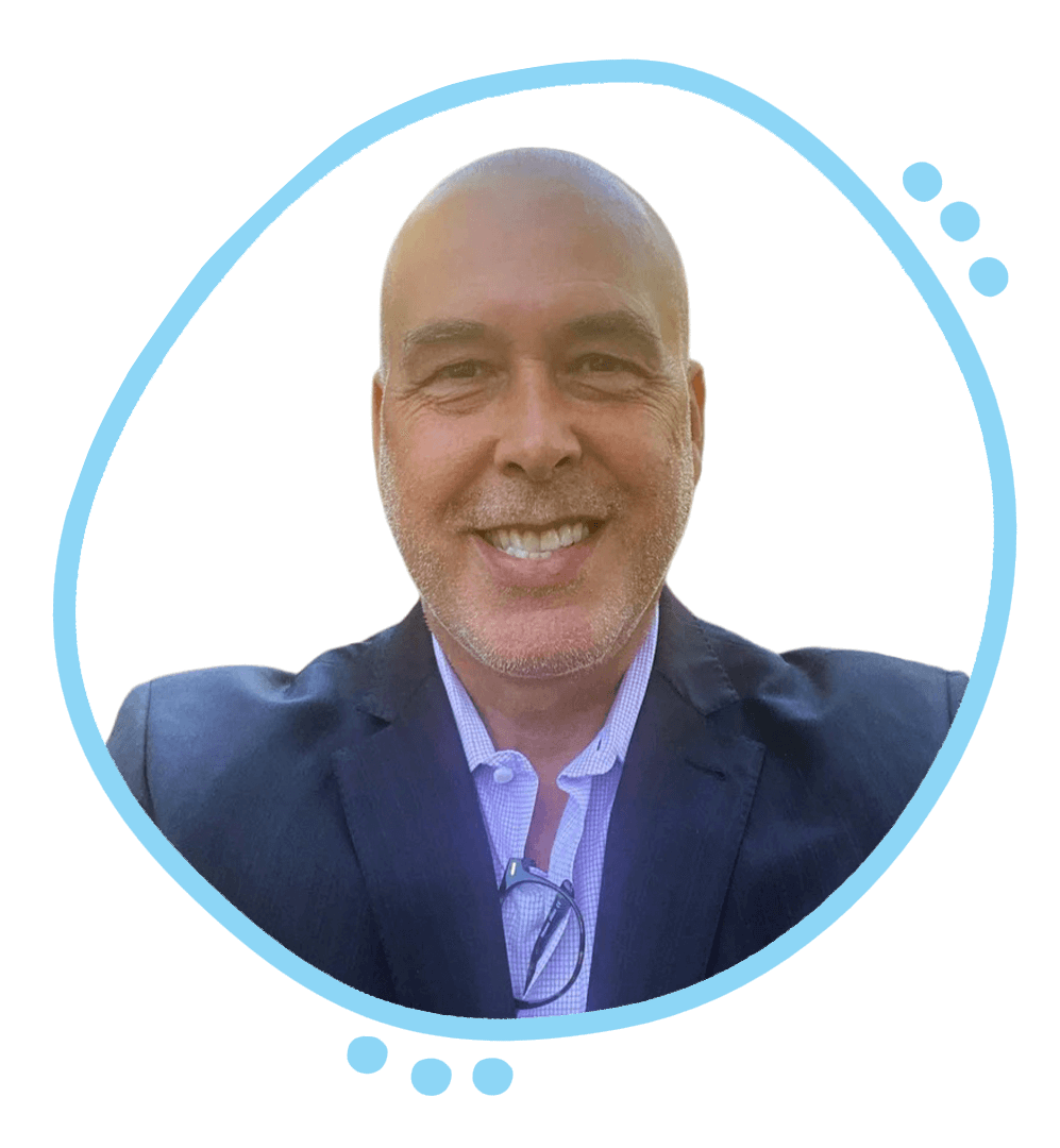 Smiling man with a shaved head wearing a dark pinstripe suit and light blue shirt.