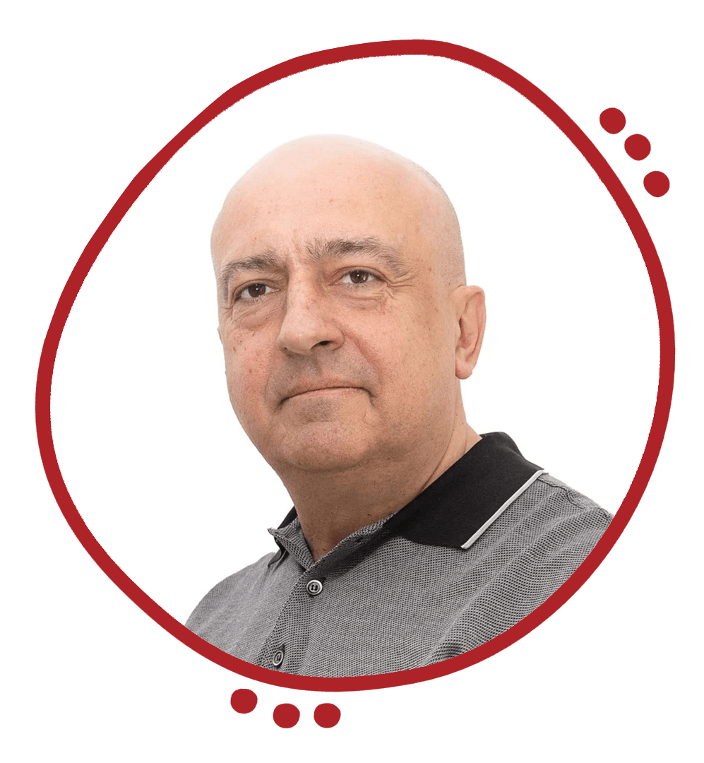 A middle-aged, bald man with light skin wearing a gray polo shirt with black collar and a small checkered pattern, posing against a plain white background.