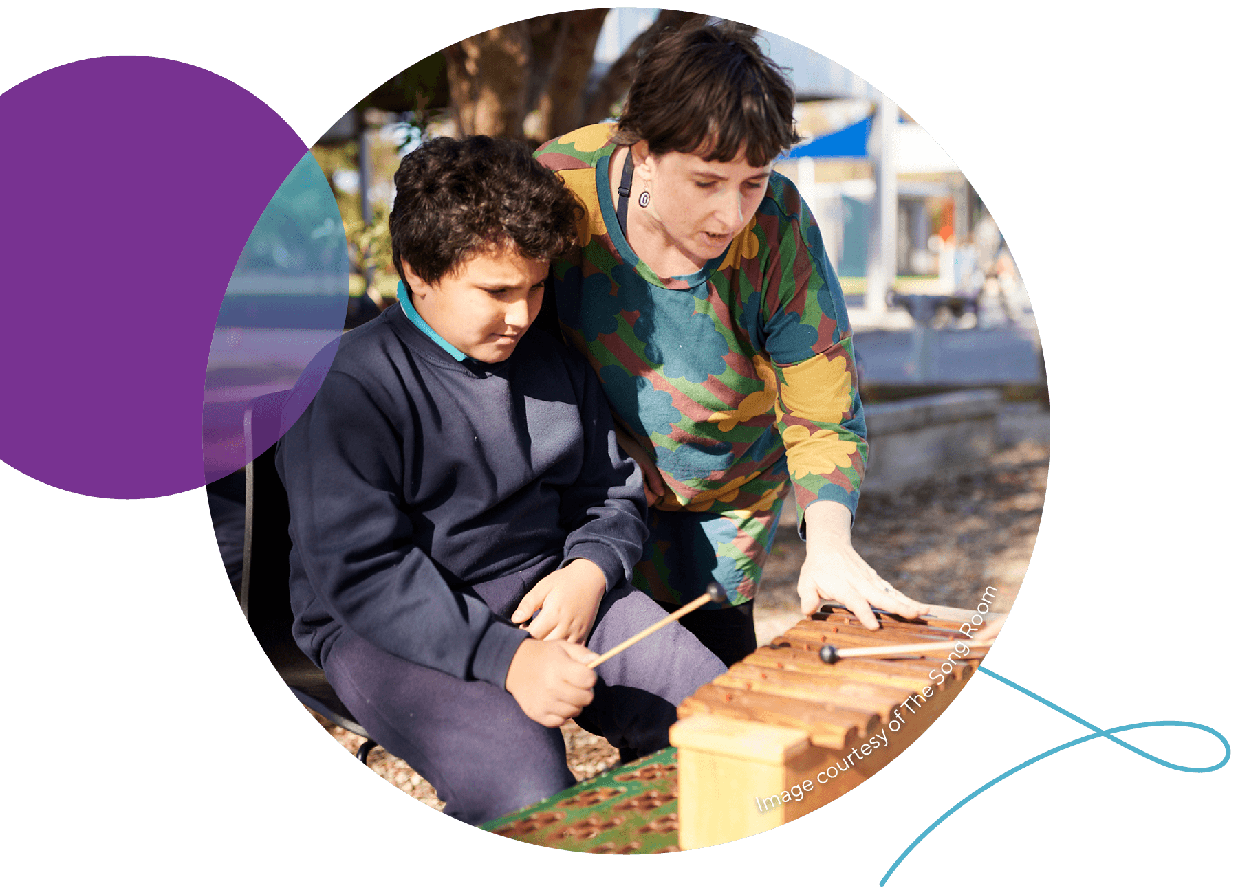Music teacher with student playing xylophone