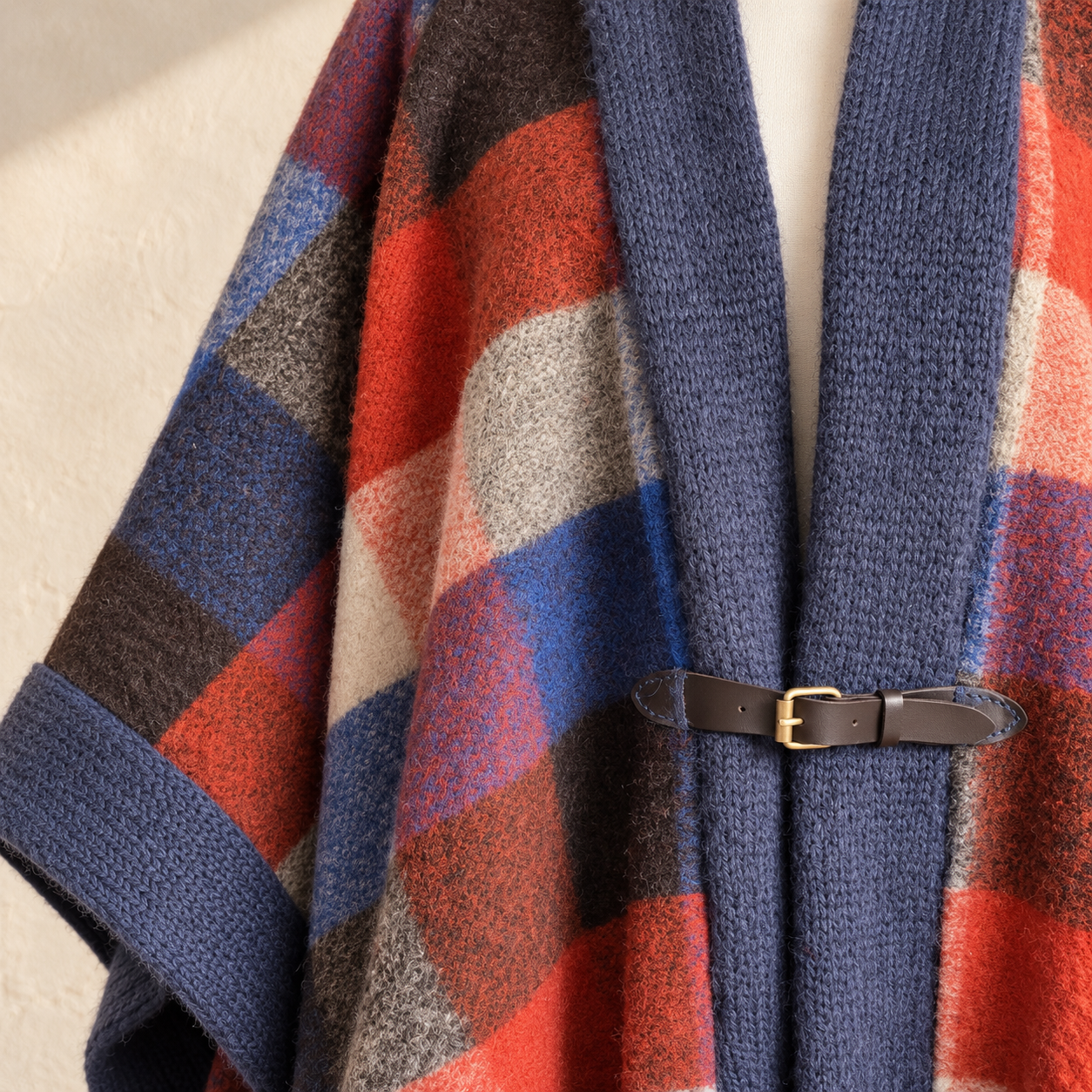 Wollponcho mit Karomuster und Lederverschluss.png