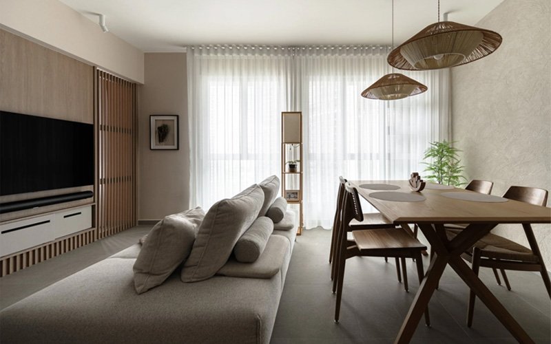 Modern living room with sofa, dining table, and TV wall.