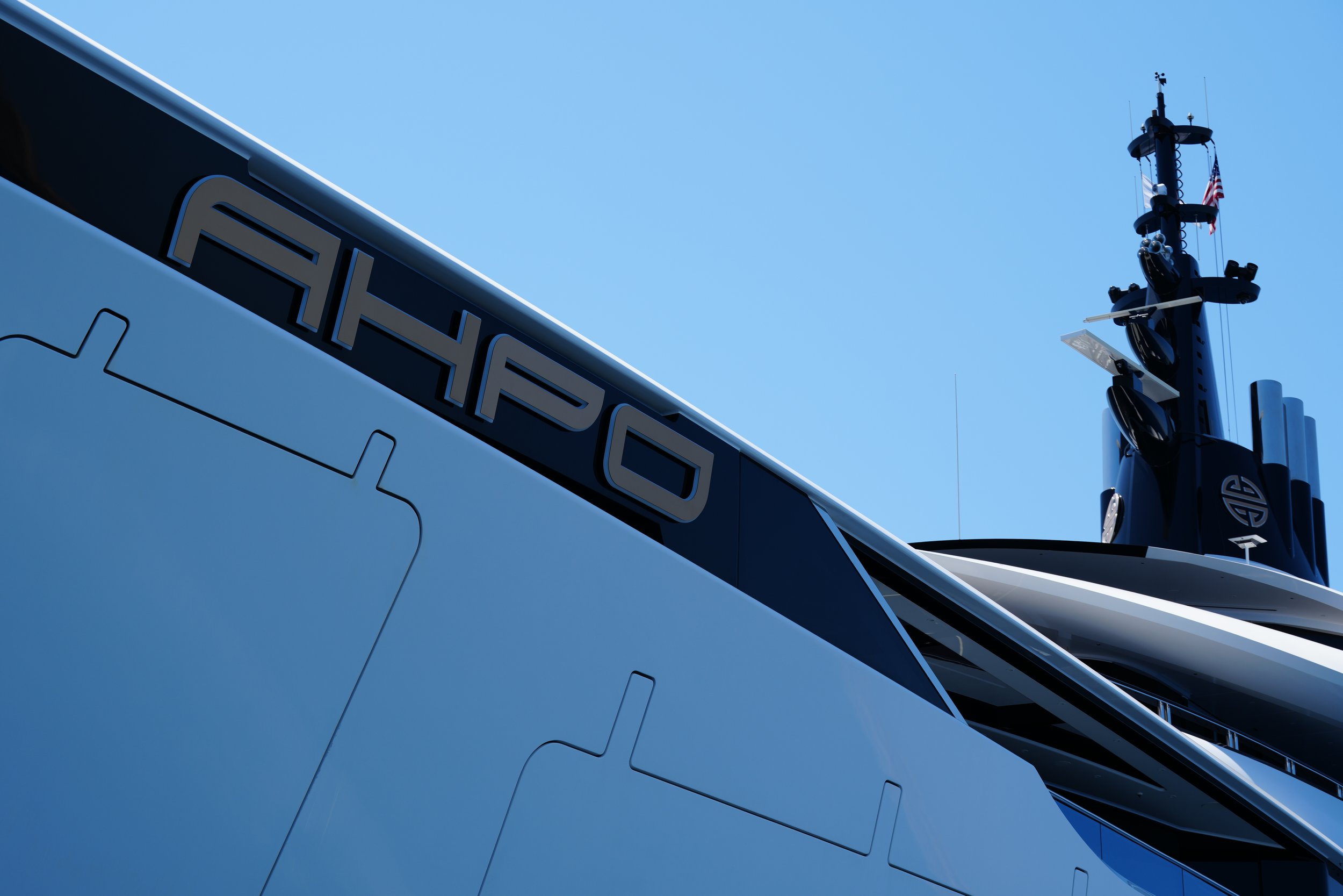 Close-up of the side of a yacht with the name 'A/HD' visible, and a large navigation radar or antenna mast on top.