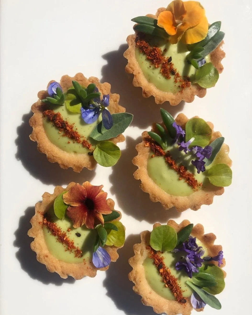 Yellow tarts with a floral garnish