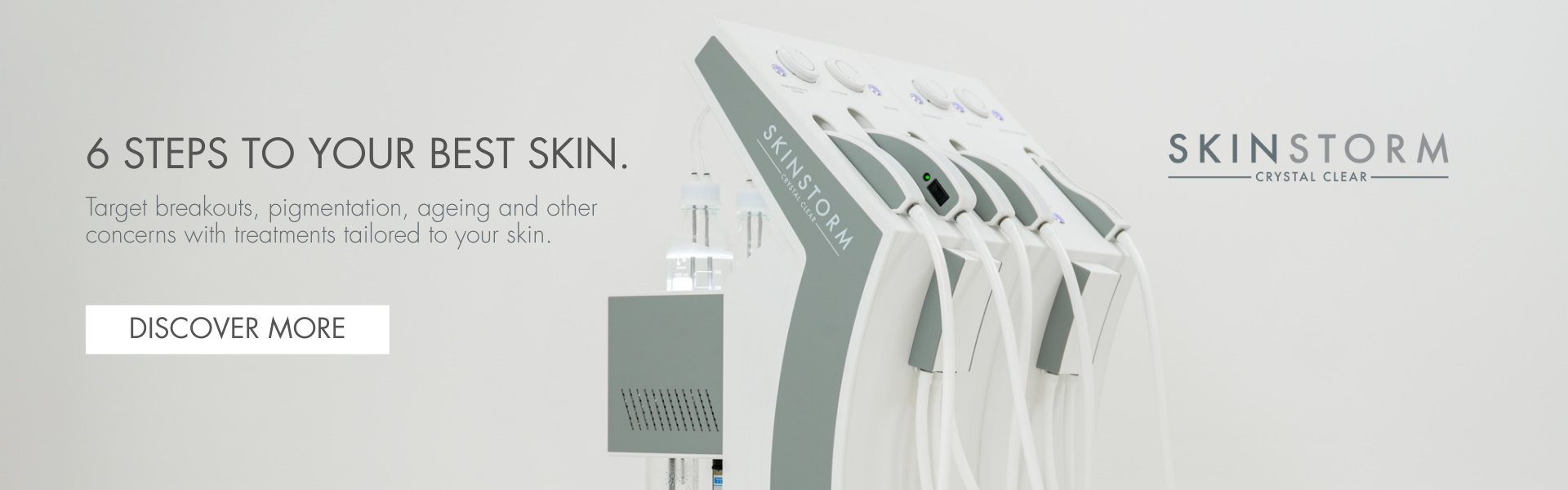 A skincare treatment device with multiple white hoses connected to it, positioned against a plain light background.