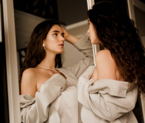 Woman looking at her reflection, representing soul astrology and self-discovery through the birth chart.