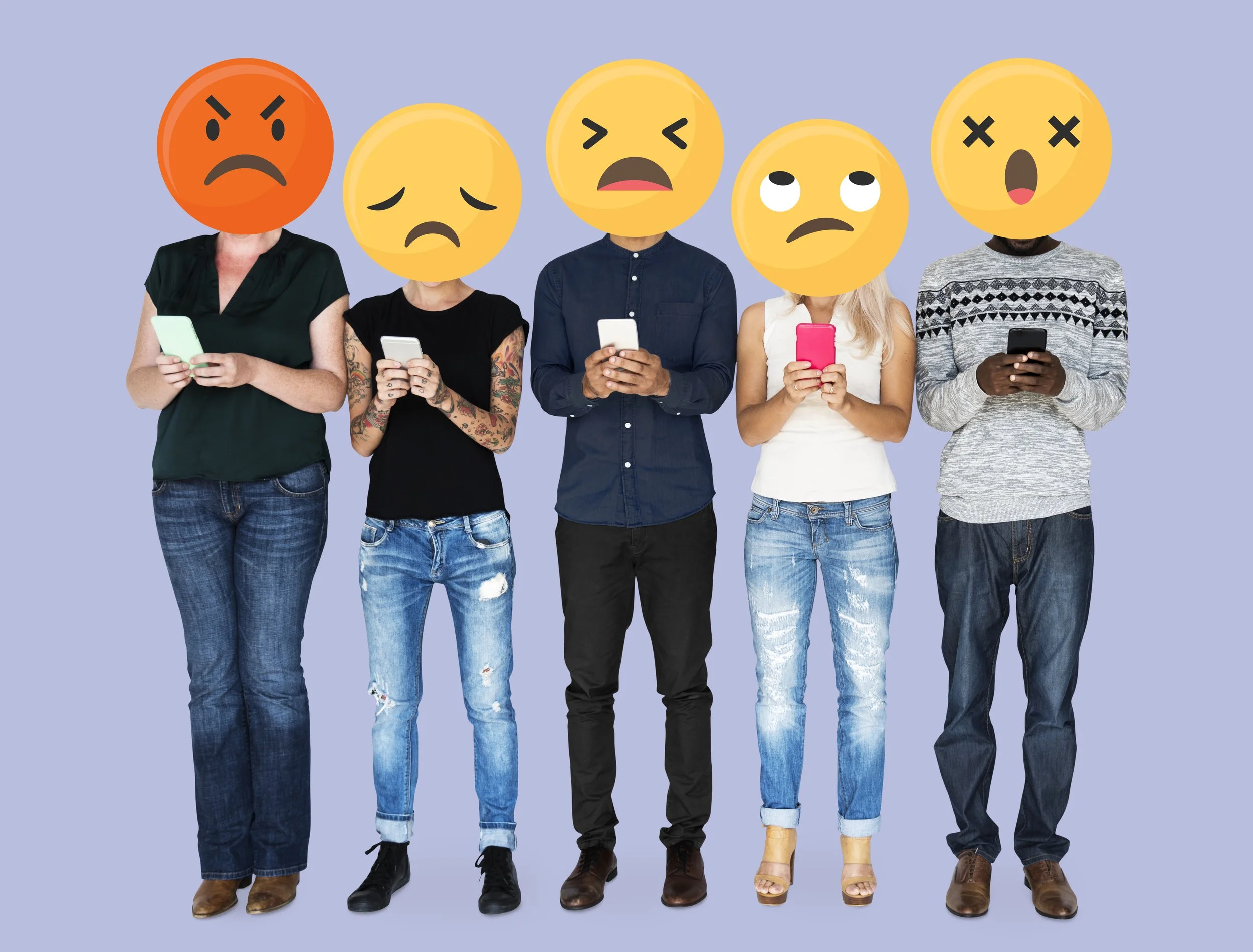 Group of people using phones with large emoji faces expressing anger, sadness and frustration, representing unspoken emotions.