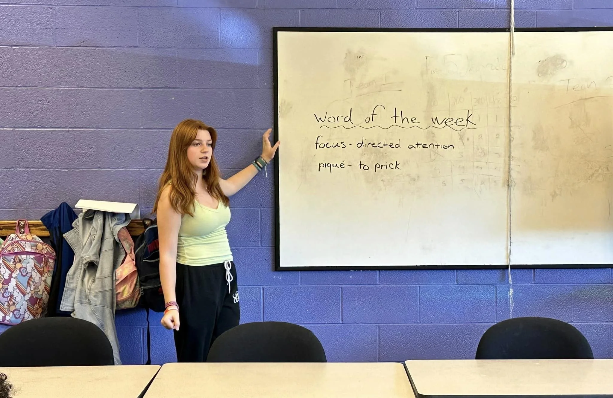 Teenage girl teaching ballet terminology in classroom