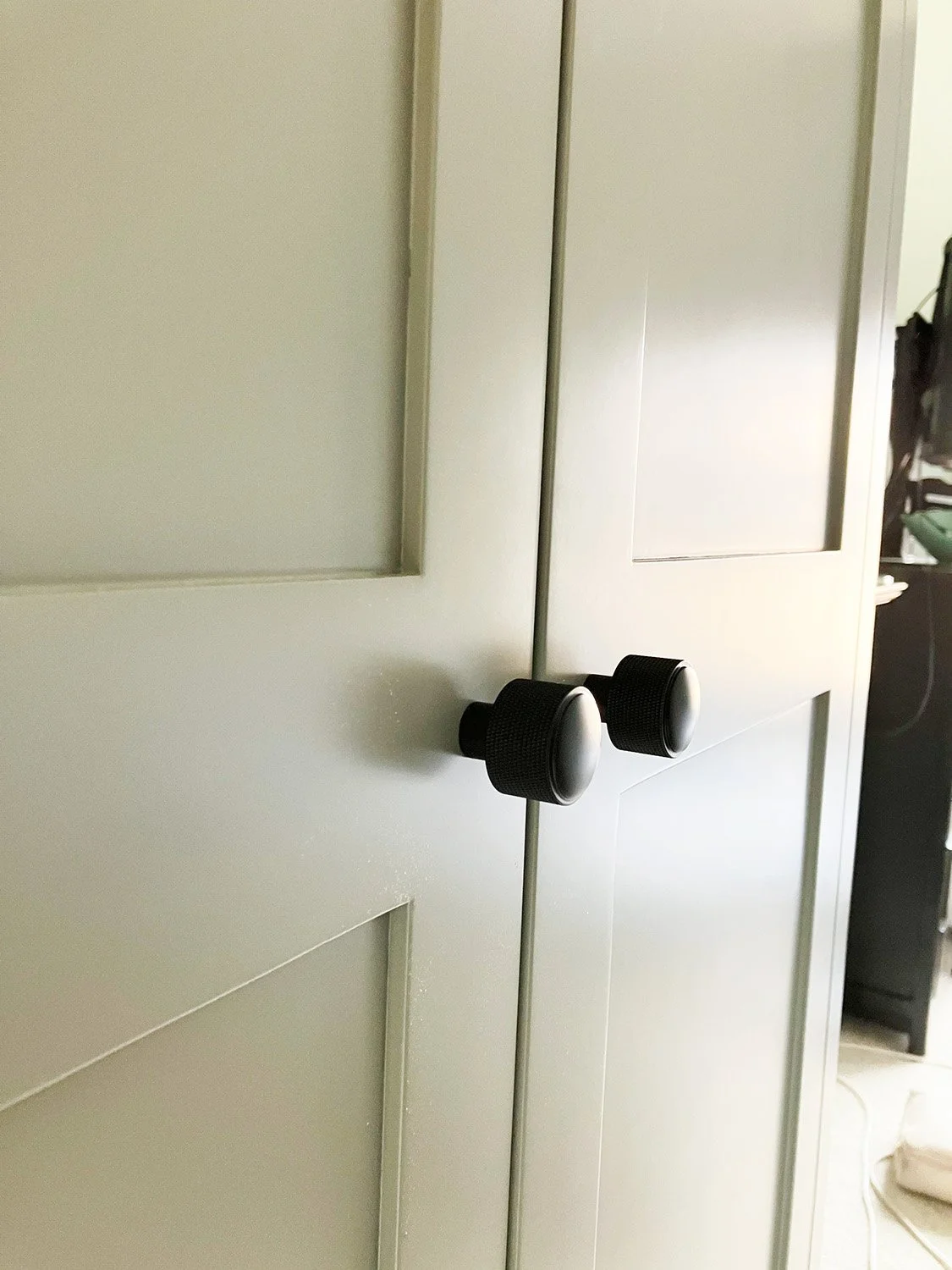 Black knurled handles by Plank contract with the smooth grey shaker wardrobe doors in Crouch End, London