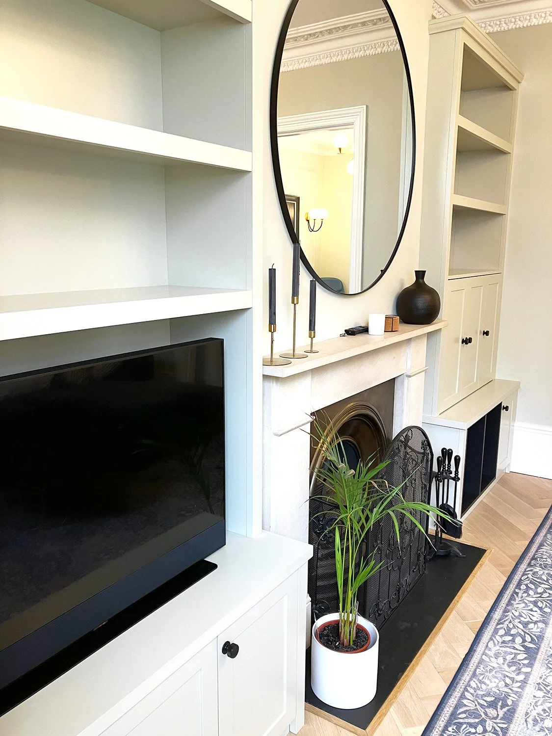 Elegant shaker cupboards and shelves sit either side of a fireplace in Finsbury Park, London