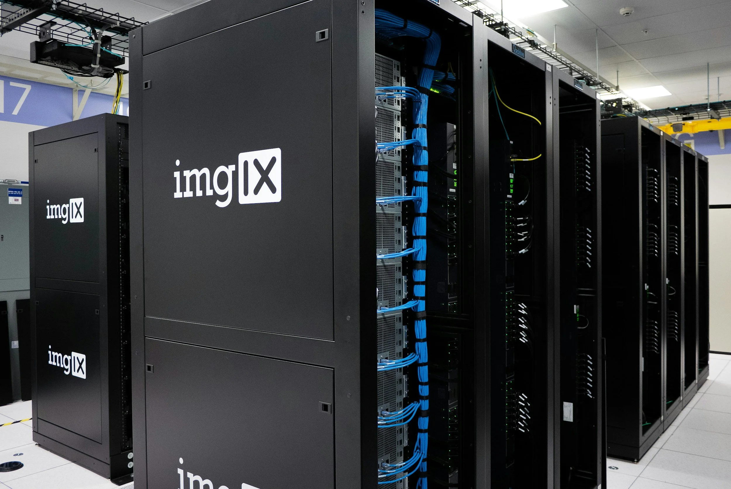 Server racks in a data center with blue network cables and the 'imgIX' logo on the side.