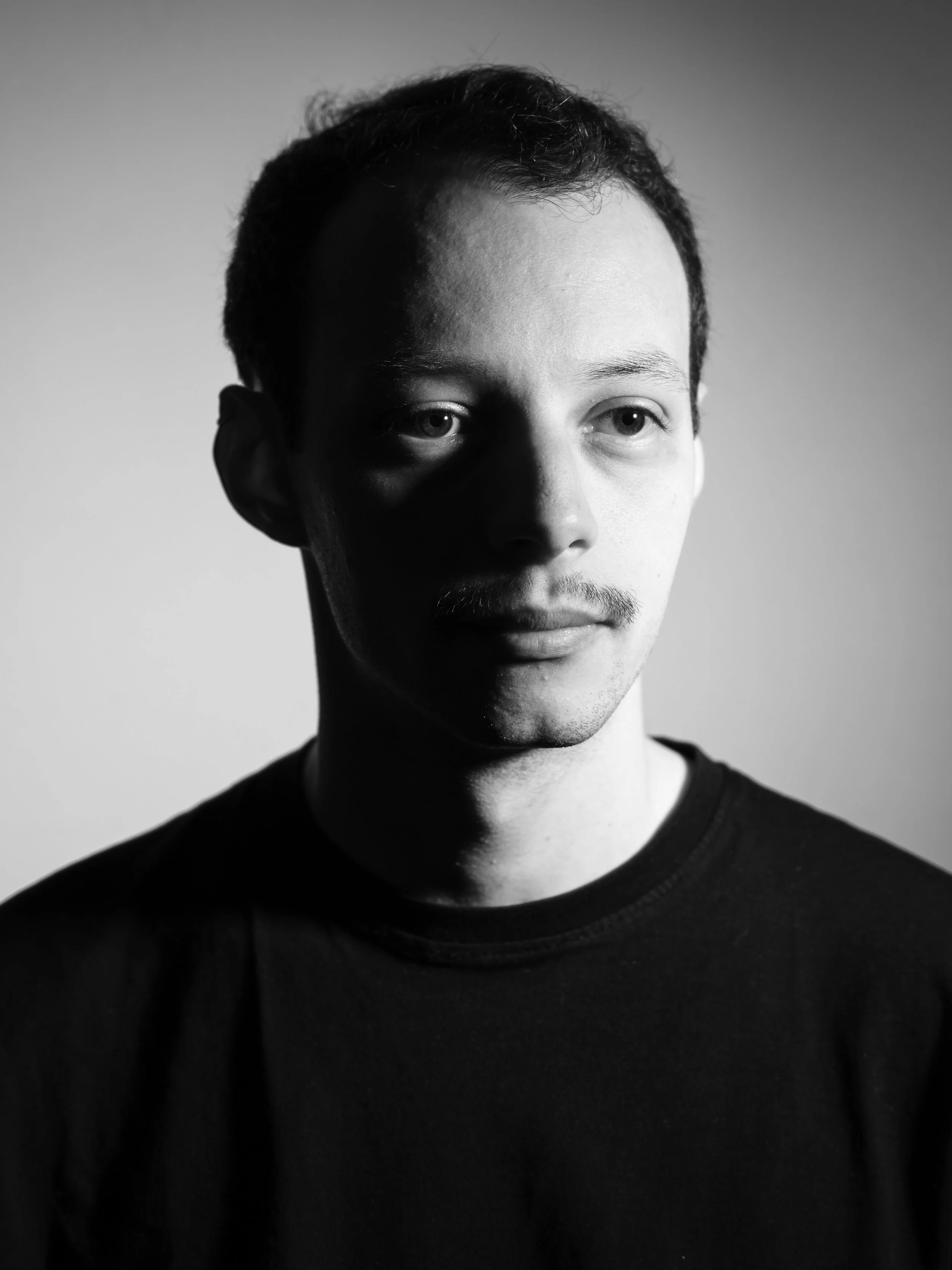 Portrait en noir et blanc du photographe franco-algérien Sami Boudra. Black and white portrait of the franco-algerian photographer Sami Boudra.