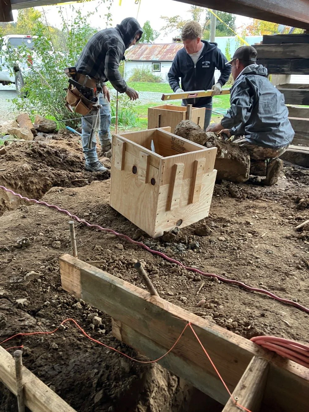 Three workmen with wooden forms under the schoolhouse