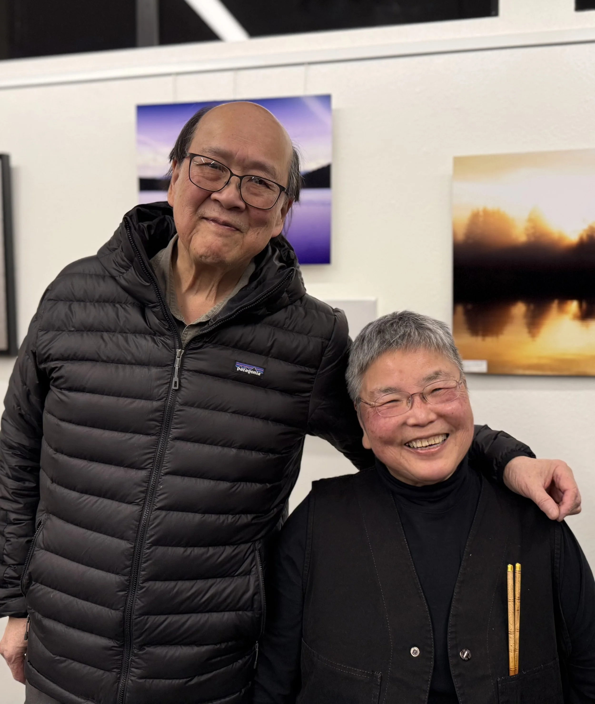 February's guest poet Alan Lau and sound artist Susie Kozawa pose at Open Mic, 2026.