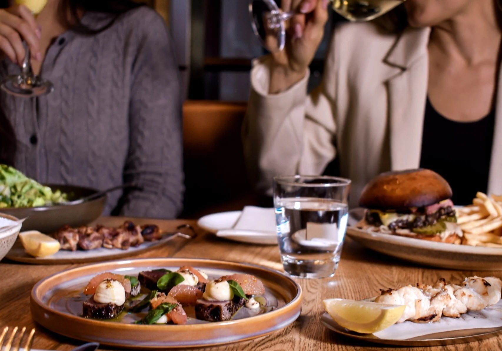 Two guests enjoying lunch and wine at The Glass Goose rooftop restaurant in Auckland CBD