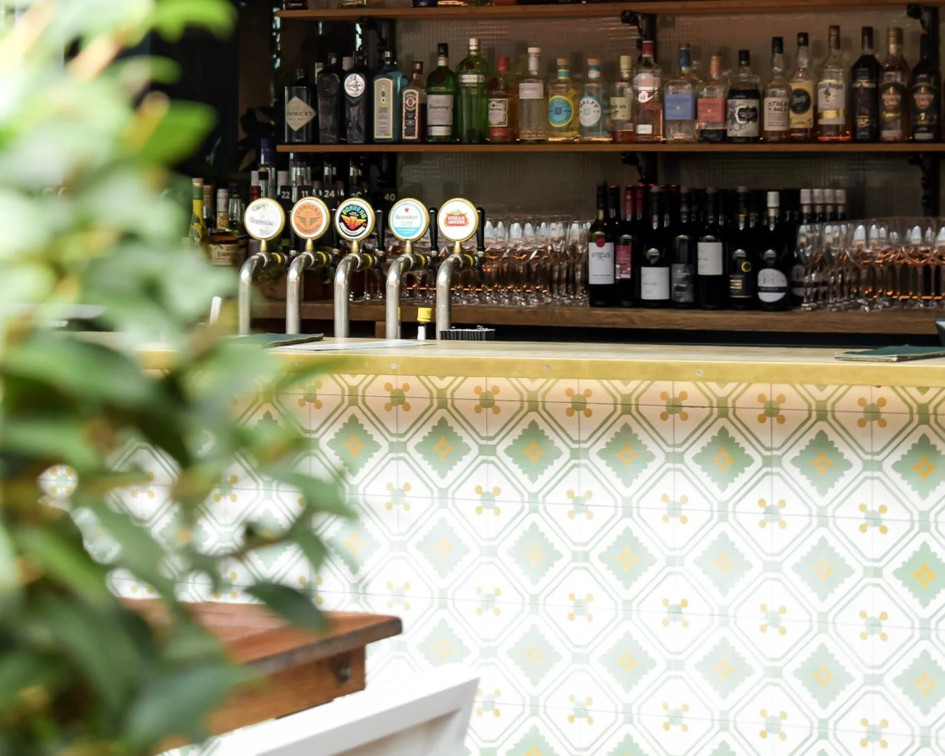 Beer taps and gin selection behind the patterned tiled bar at The Glass Goose, Auckland