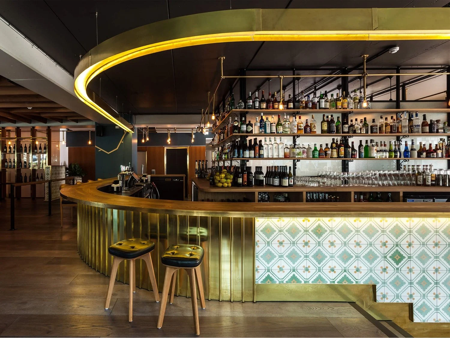 Curved brass bar and tiled frontage inside The Glass Goose rooftop venue