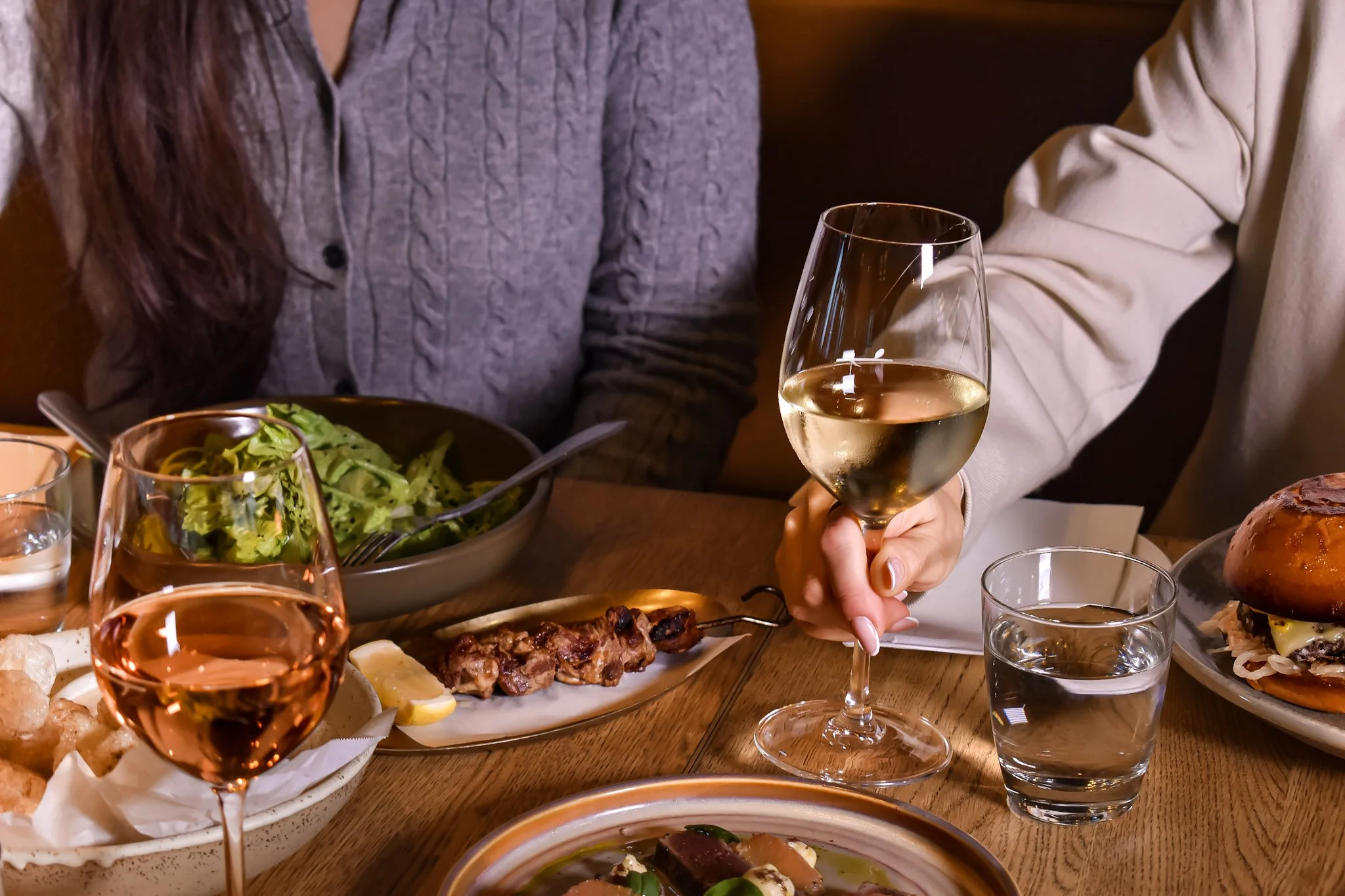 Guests sharing food and wine at The Glass Goose restaurant