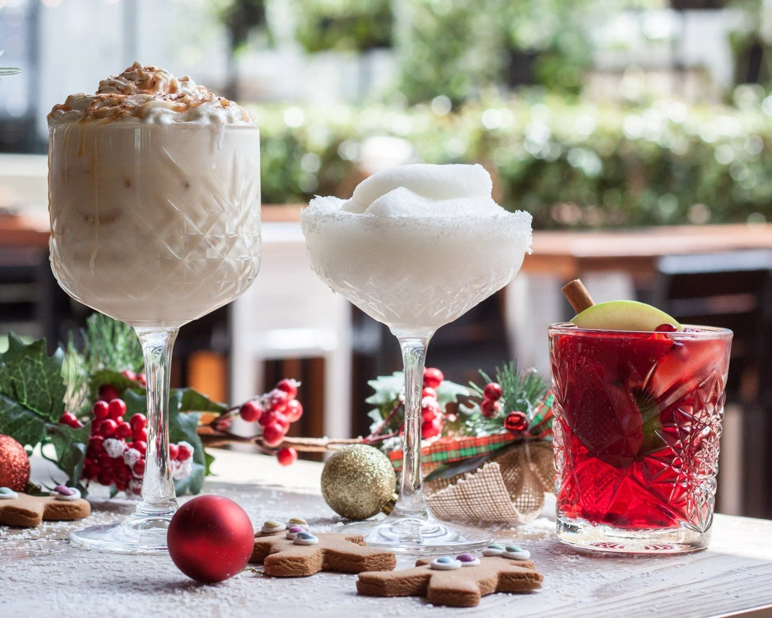 Festive Christmas cocktails with gingerbread and baubles on a rooftop table