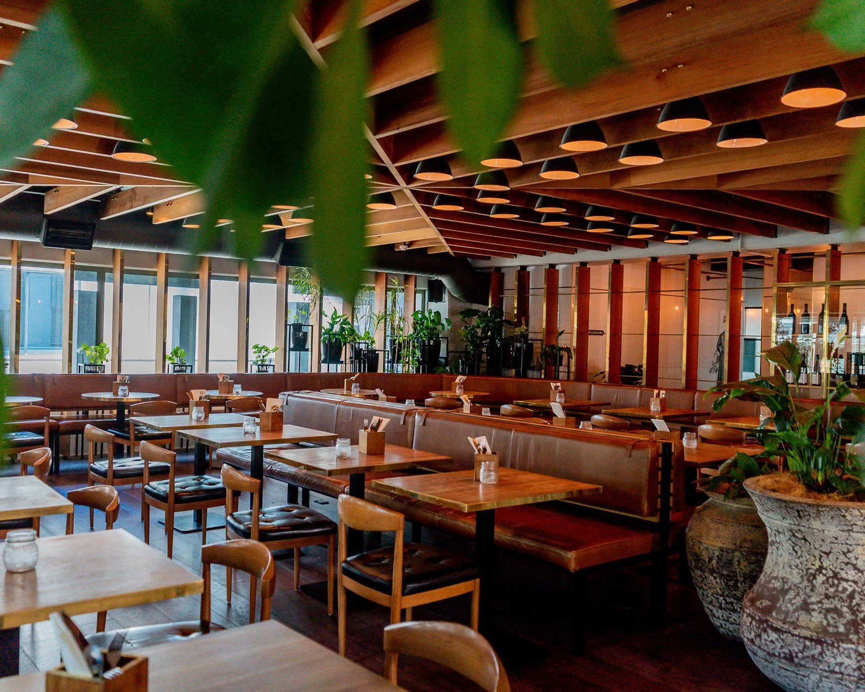 Indoor dining room with leather banquettes and timber ceiling, set for group dining in Auckland CBD