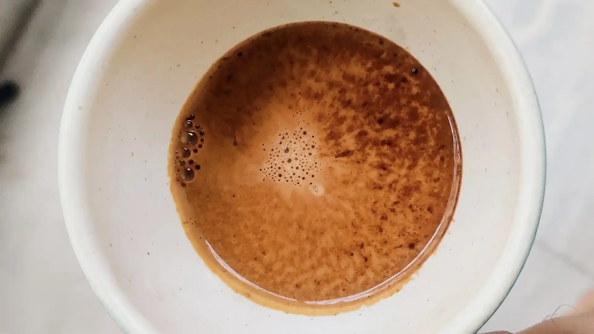 Top view of a coffee cup filled with brewed coffee.