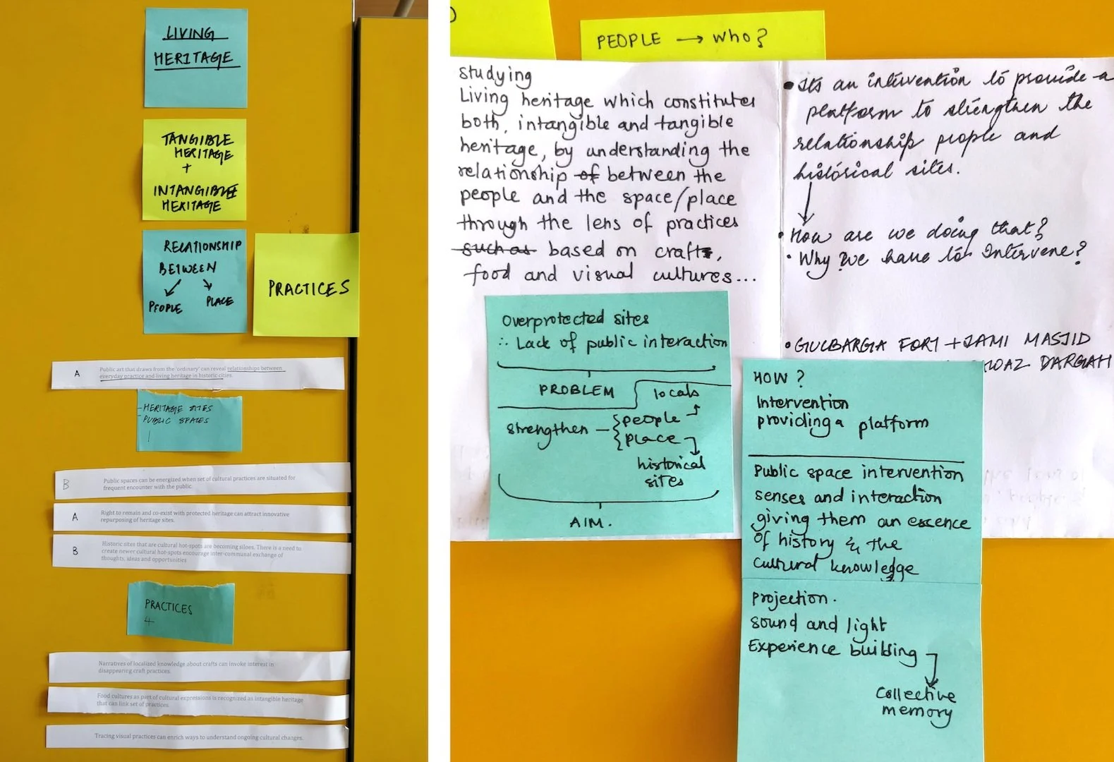 A classroom bulletin board with colorful sticky notes and handwritten notes on a paper. Blue sticky notes say "LIVING HERITAGE," "RELATIONSHIP BETWEEN PEOPLE AND PLACE," and "PRACTICES." Yellow sticky notes say "TANGIBLE HERITAGE + INTANGIBLE HERITAGE," "PRACTICES," and "PEOPLE → who?" There are pasted paper strips with text about heritage practices, cultural sites, and community involvement, as well as handwritten notes discussing heritage, public interaction, and cultural memory.