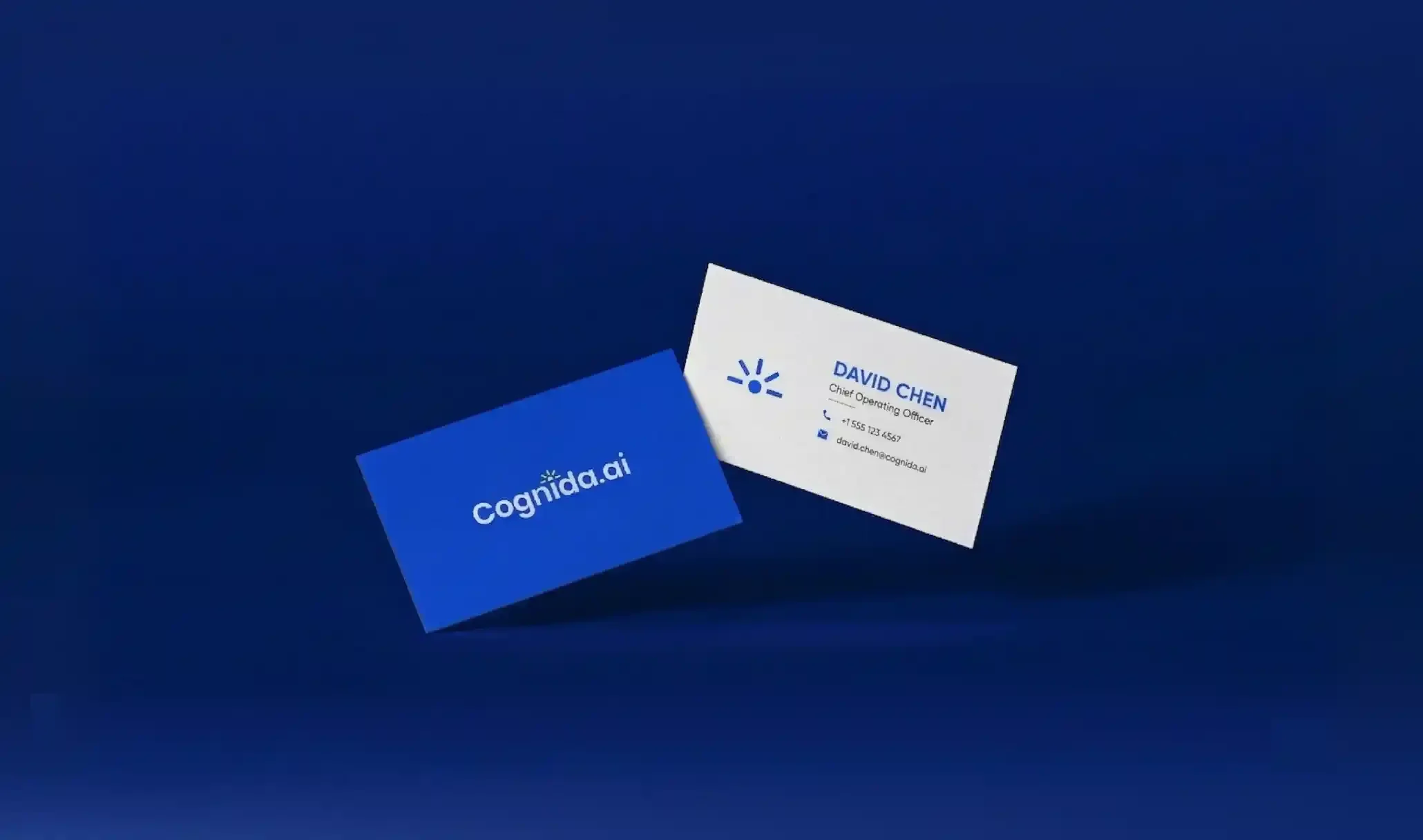 Business cards on a dark blue surface, one with the logo 'Cognída.ai' and the other with the name 'David Chen', title 'Chief Operating Officer', and contact information.