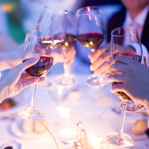 Guests toasting wine glasses at a Kansas City wedding reception coordinated by Liz Ashley Events