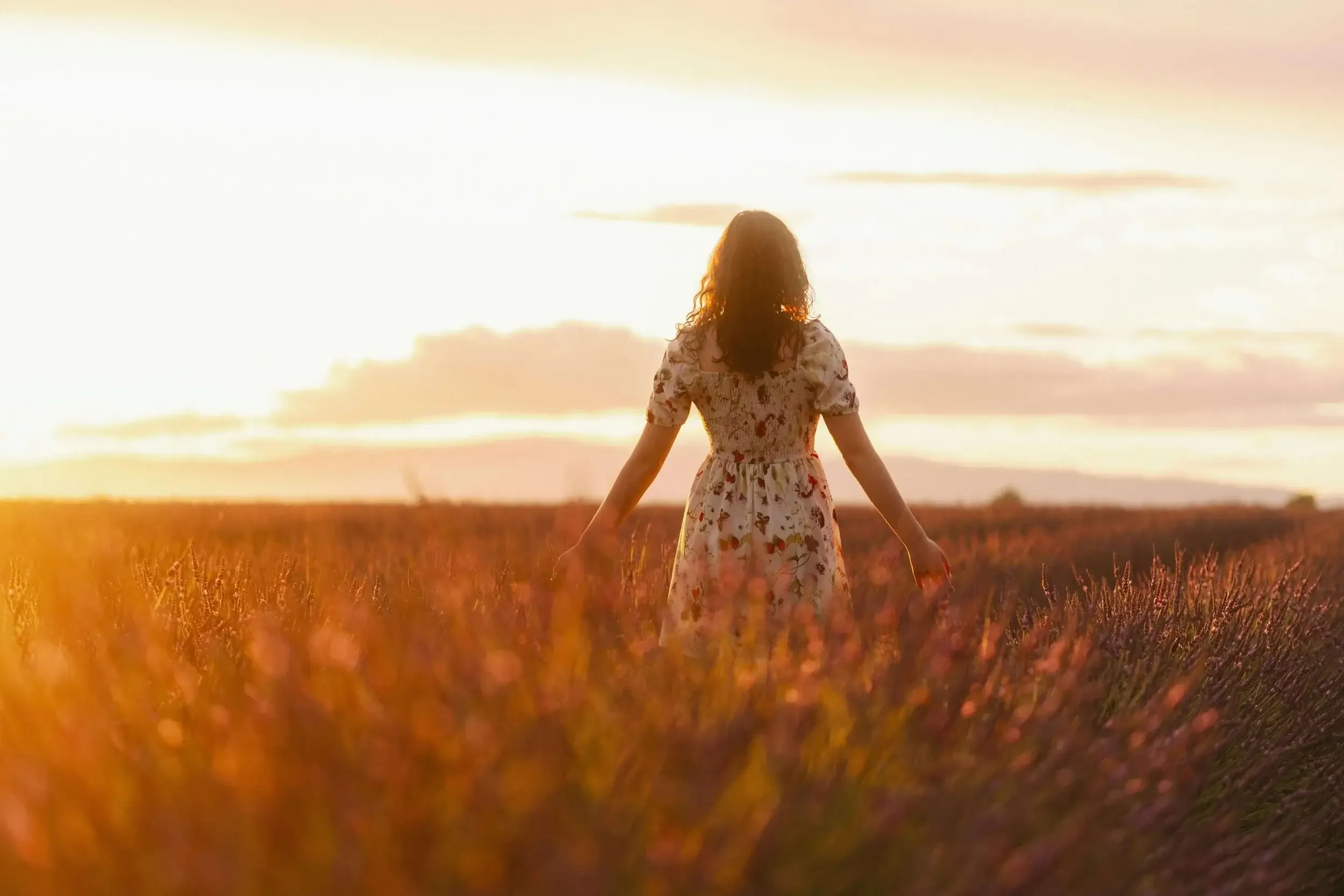 a sepia tinted photo of a woman walking in a field