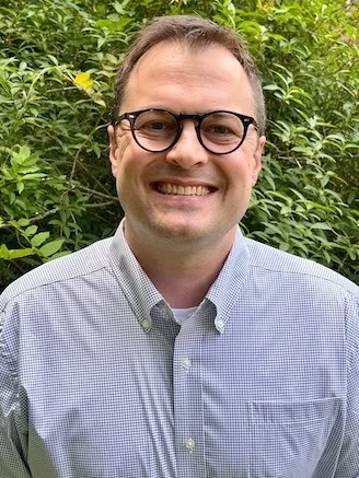 david fisk, a man smiling with glasses and a blue shirt