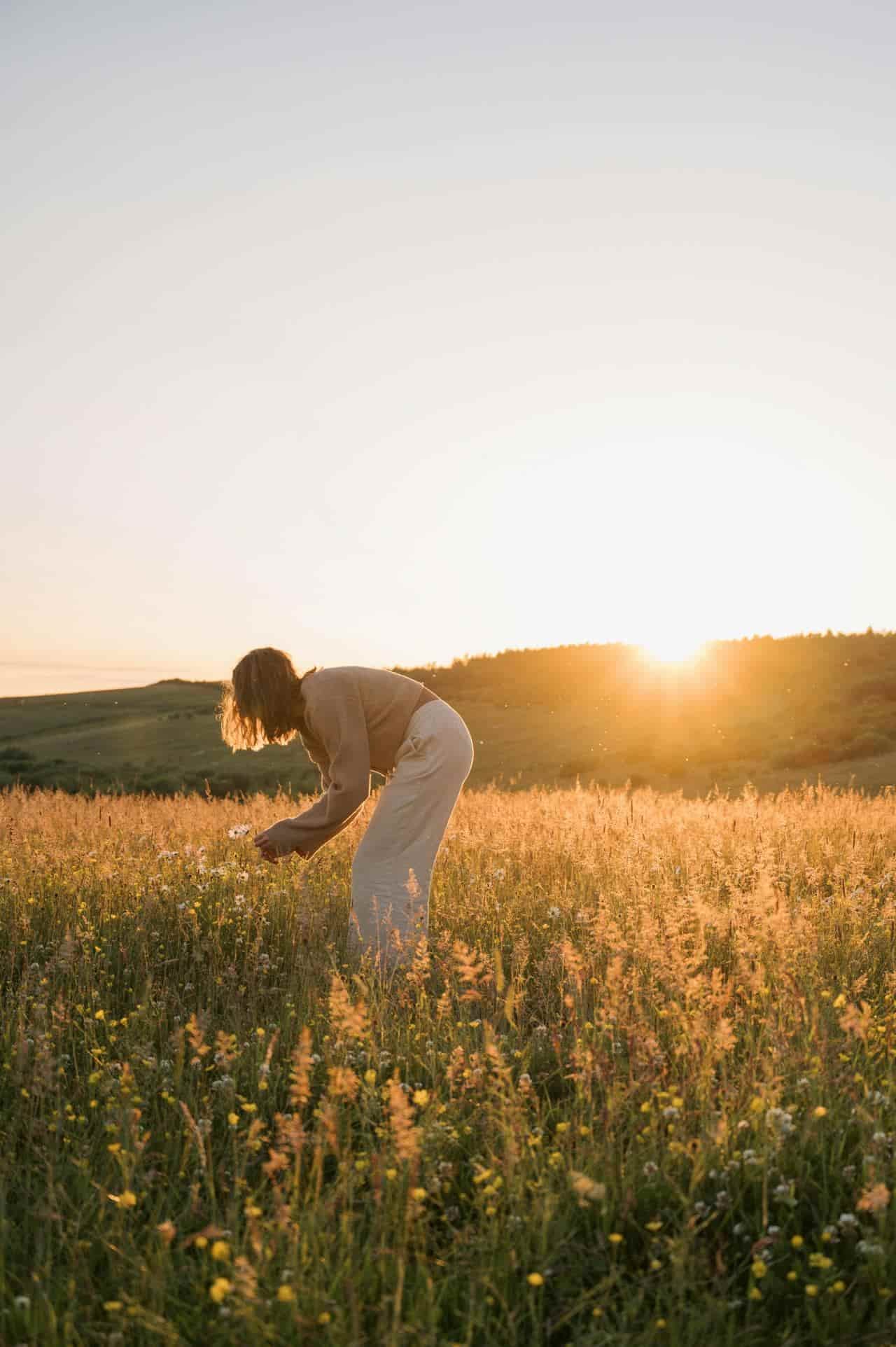 teen picking flowers in field