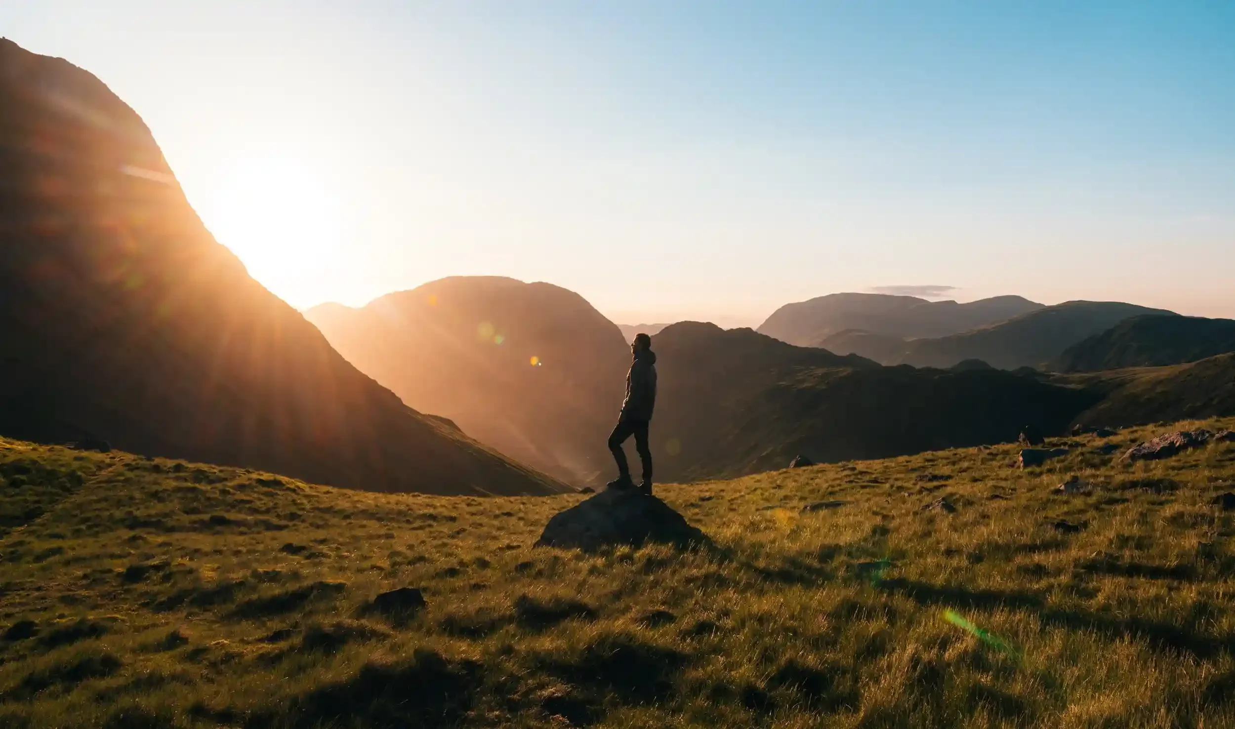 a man standing in a field on a rock