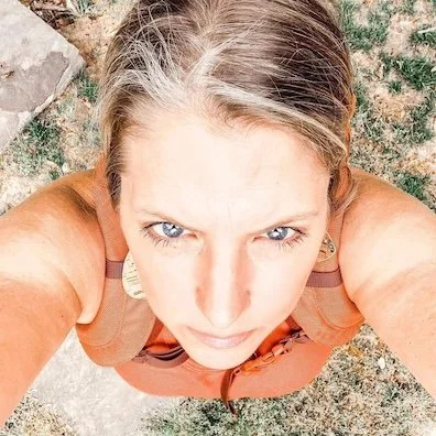 woman in orange top looking up at camera