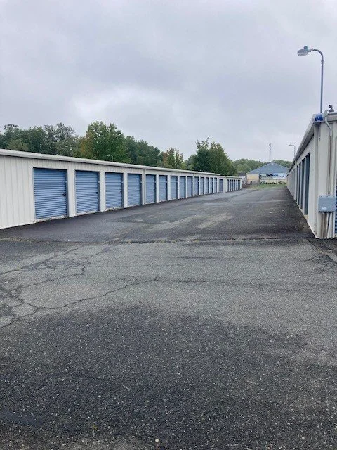 Discount Mini Storage has outdoor storage units with blue doors, a paved driveway, and a parking area.