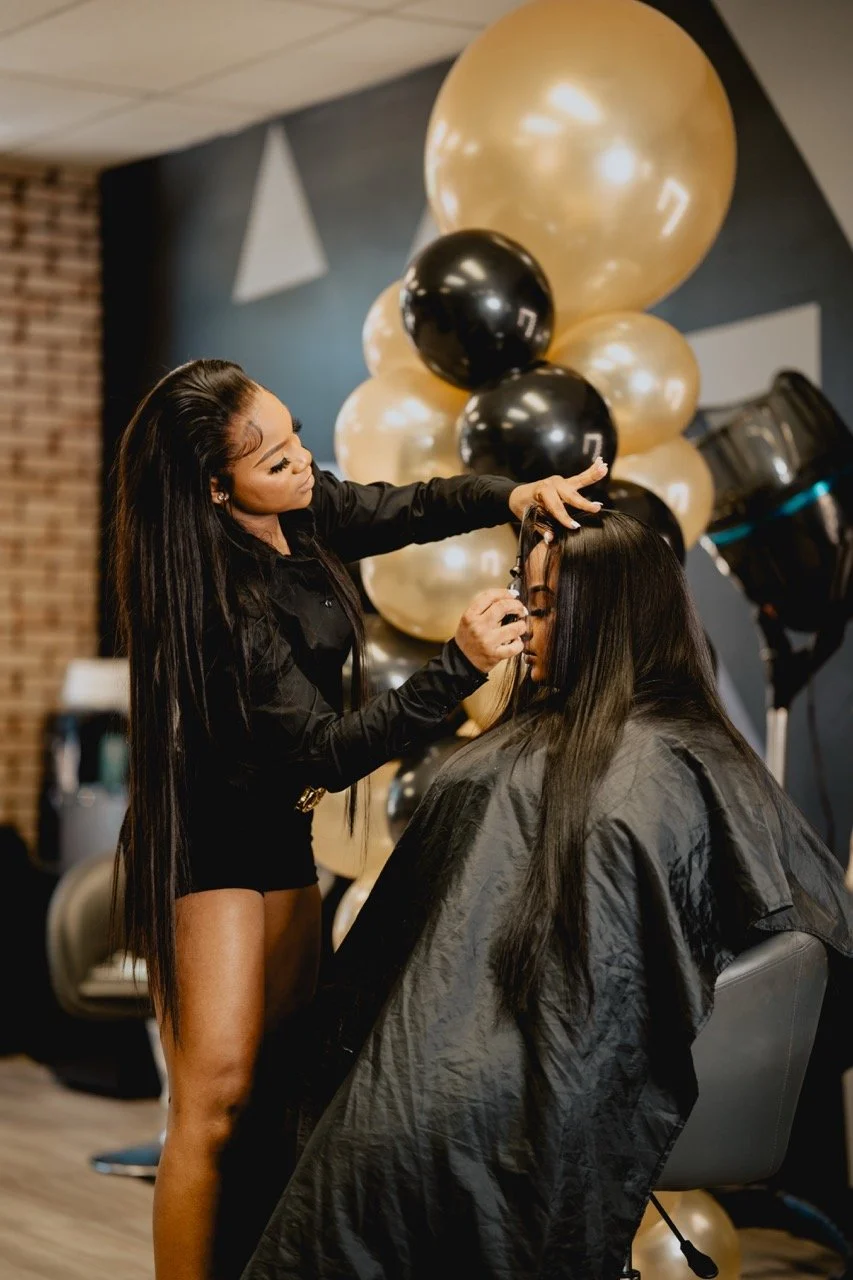 Kaniya J demonstrating a technique on a model during her hair class