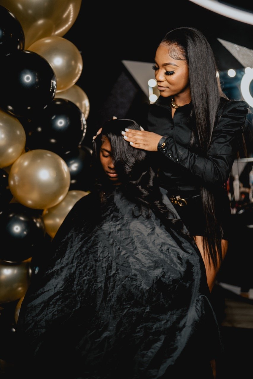 Kaniya J demonstrating a technique on a model during her hair class