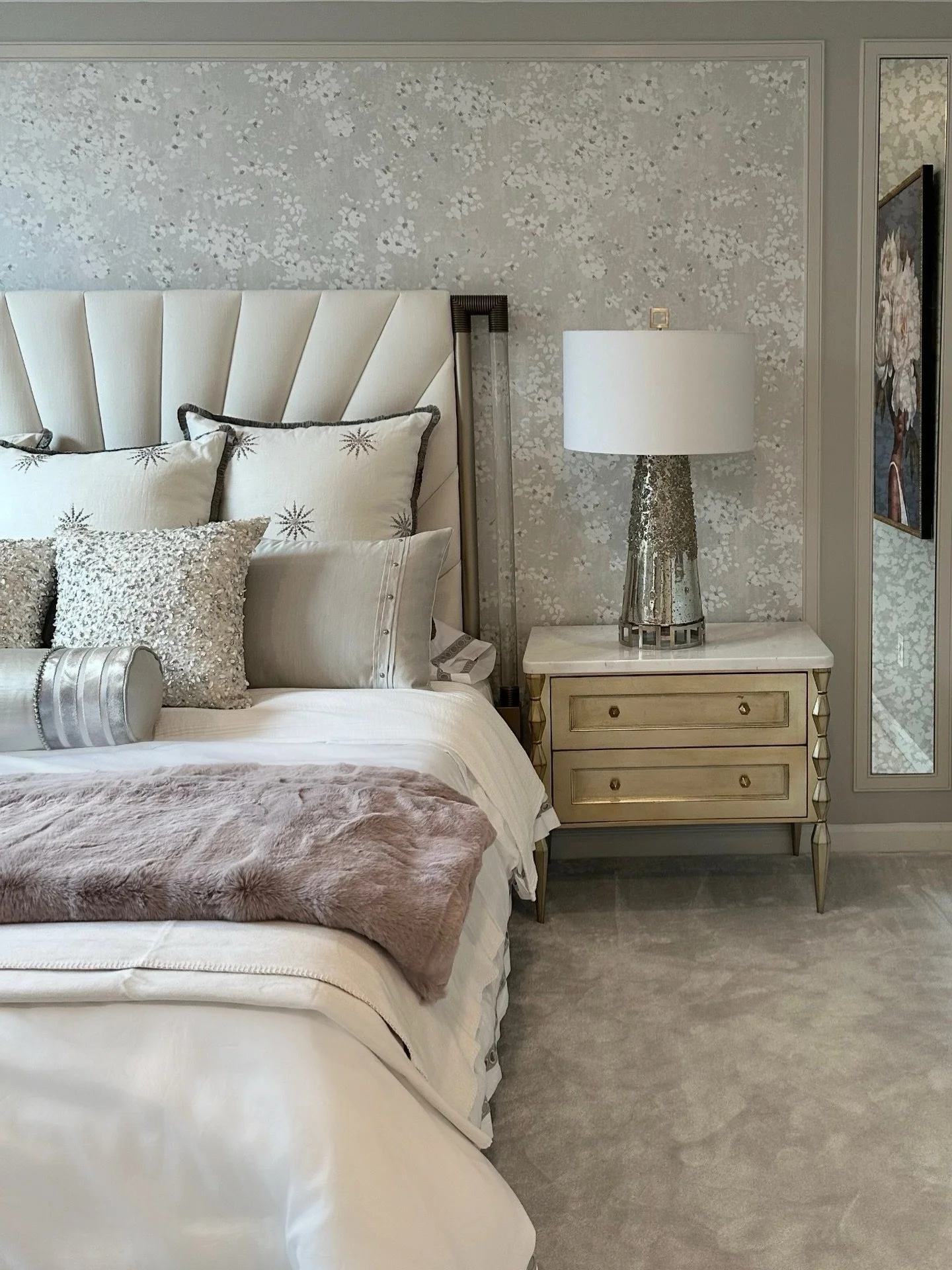 Winter is for getting cozy❄️ This neutral-toned bedroom encourages rest with delicate floral wallpaper, plush layers of accent pillows, and a touch of metallic shine from all of these elements throughout the room.

#lornagrossinteriordesign #cozybedr