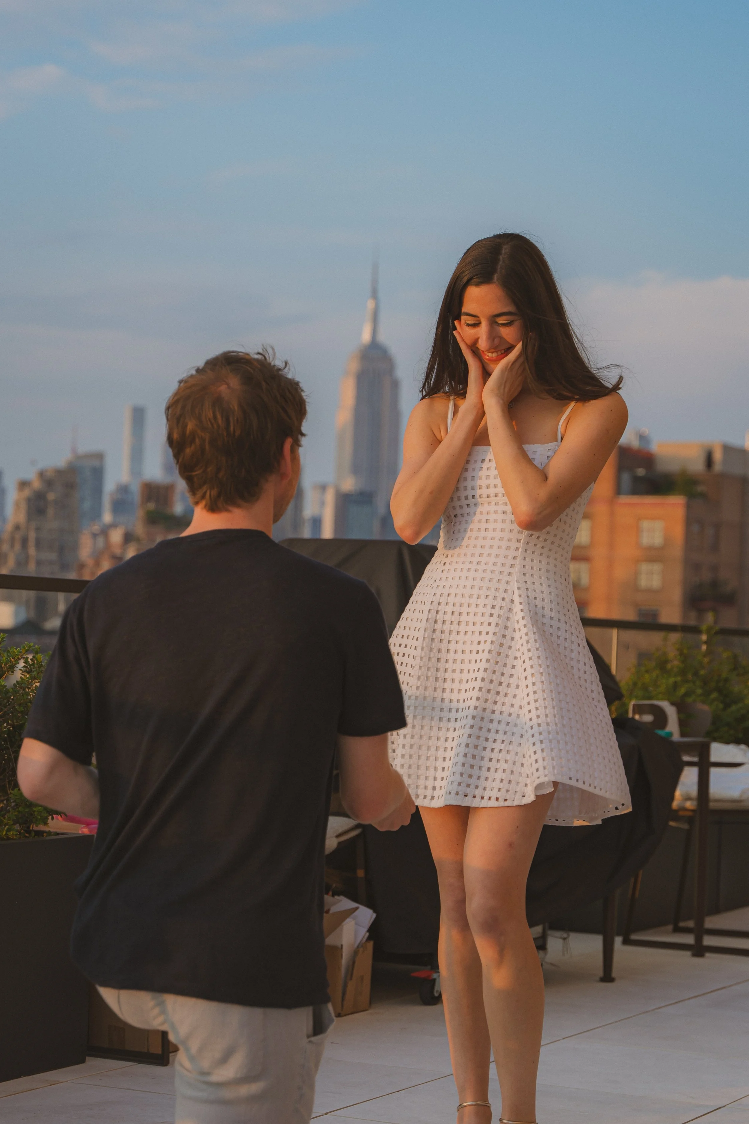 Man proposing to woman on NYC rooftop at sunset