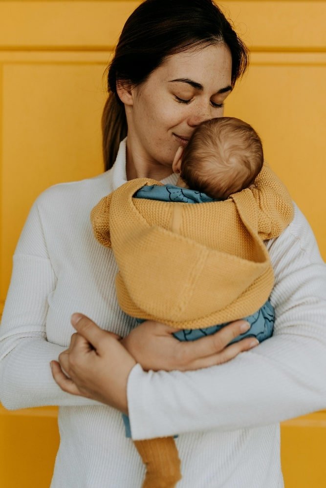 Mom sniffing top of newborn's head