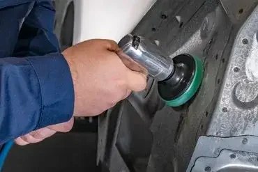Man using a griding tool for autobody repair