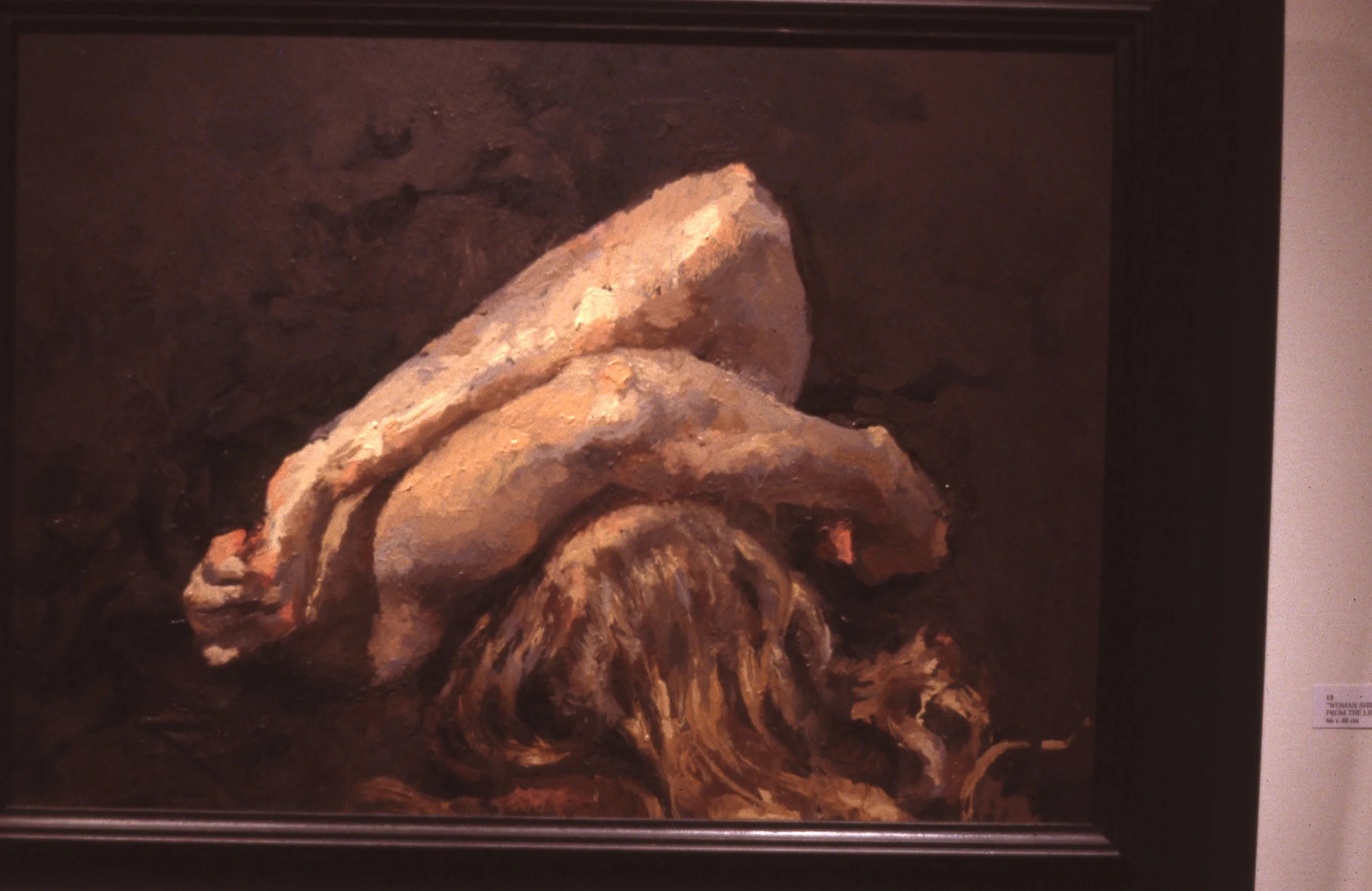 Painting of a woman lying on her side with long hair, with a large rock above her, in dark earthy tones.