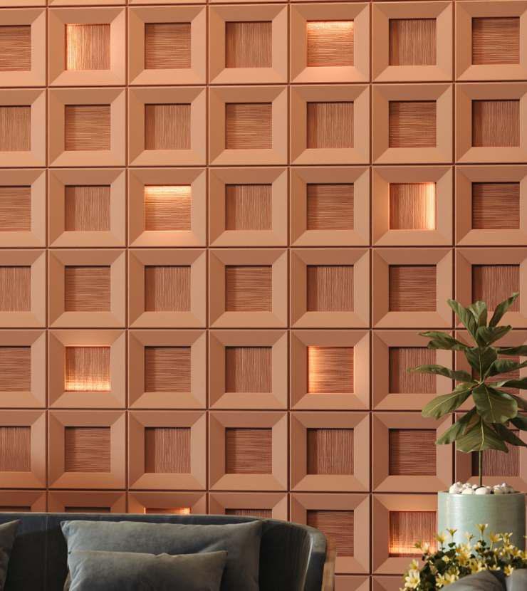 A decorative wall with 3D geometric square panel design, featuring small displays with warm lighting, in a modern interior setting with a green potted plant and a black sofa with cushion in the foreground.