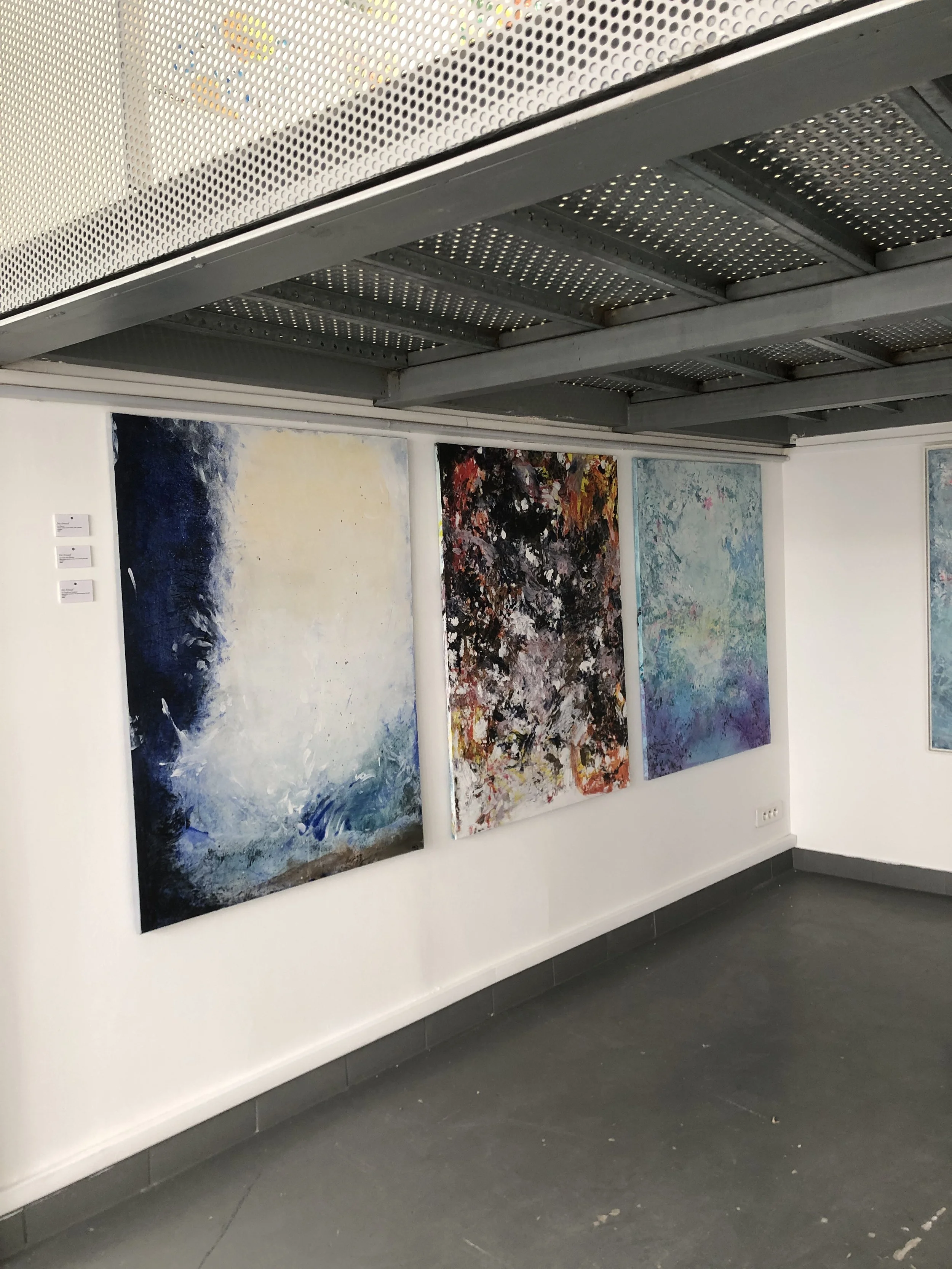 Four abstract paintings displayed on a white gallery wall, with a metal ceiling overhead. modern art, contemporary art famous artist in paris