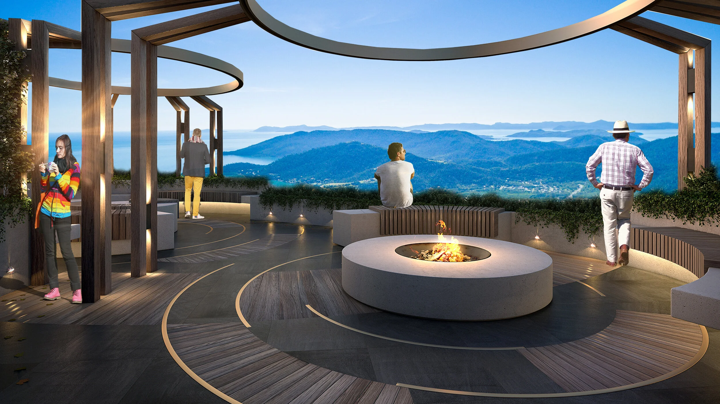 People enjoy a scenic outdoor terrace with a fire pit, overlooking mountains and a lake under a clear sky.