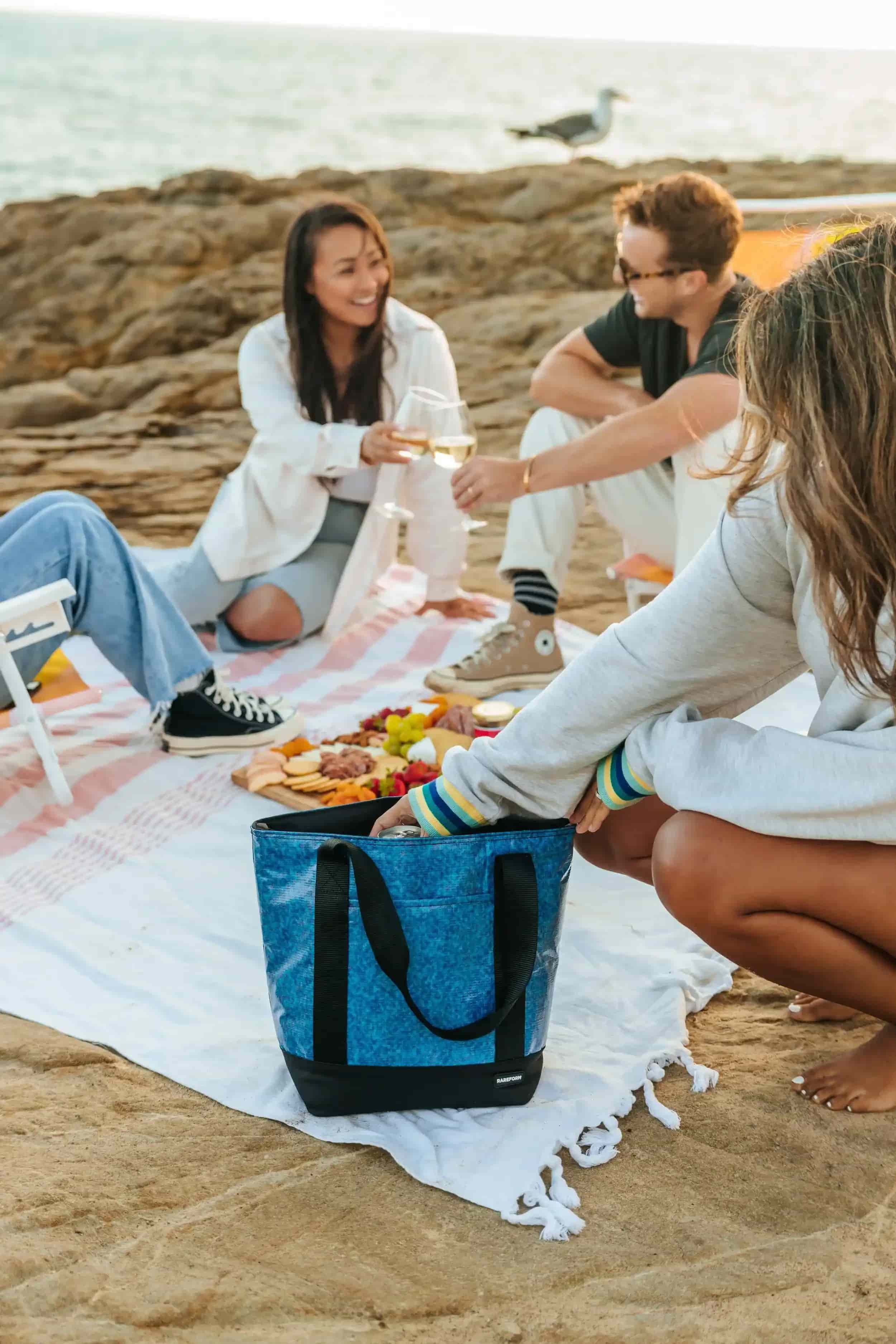 Friends enjoying a relaxed coastal picnic on the beach in Warrnambool