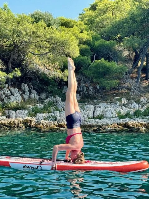 Judy doing yoga on a paddle board in Croatia