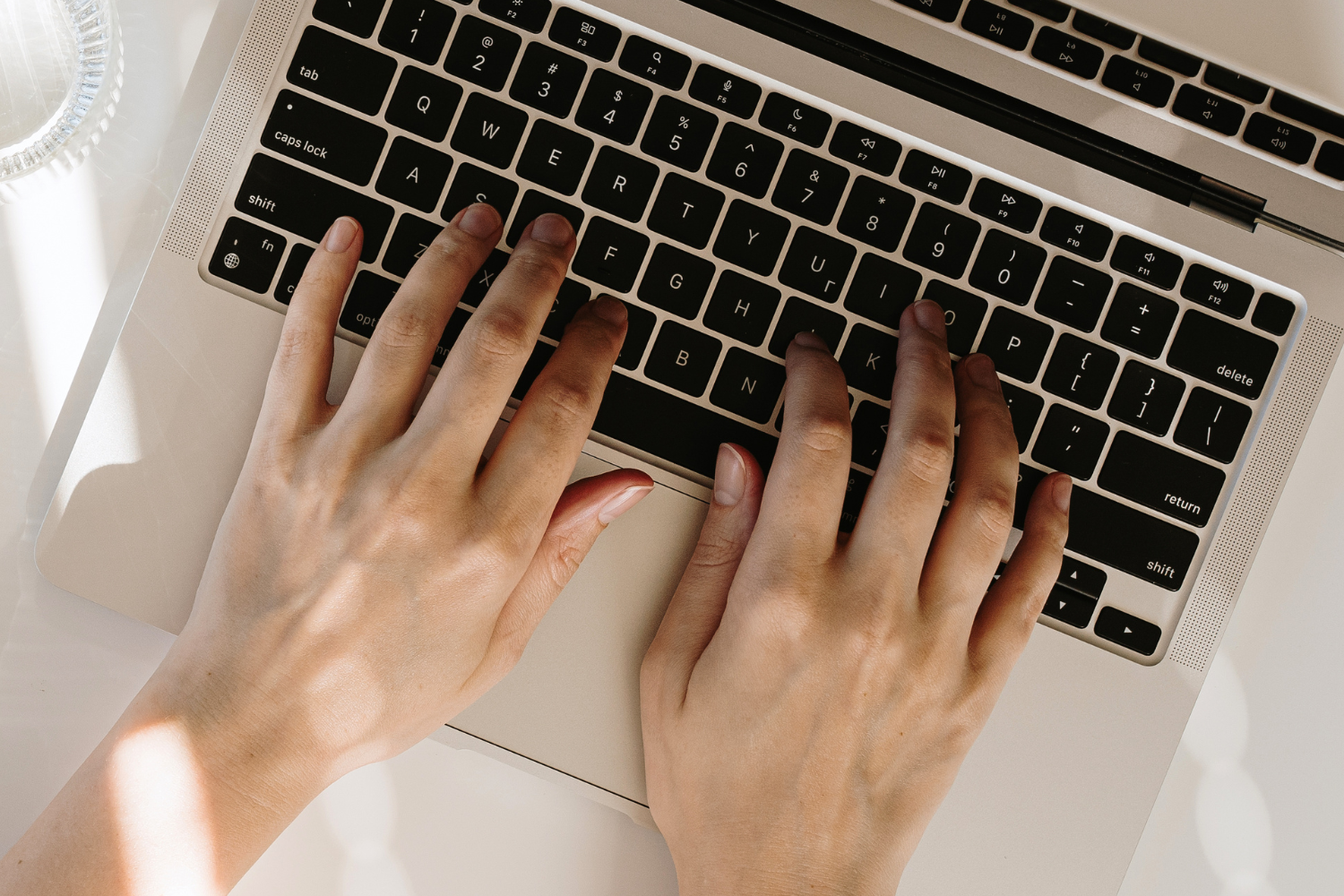 Image of a person typing at a hot desk.